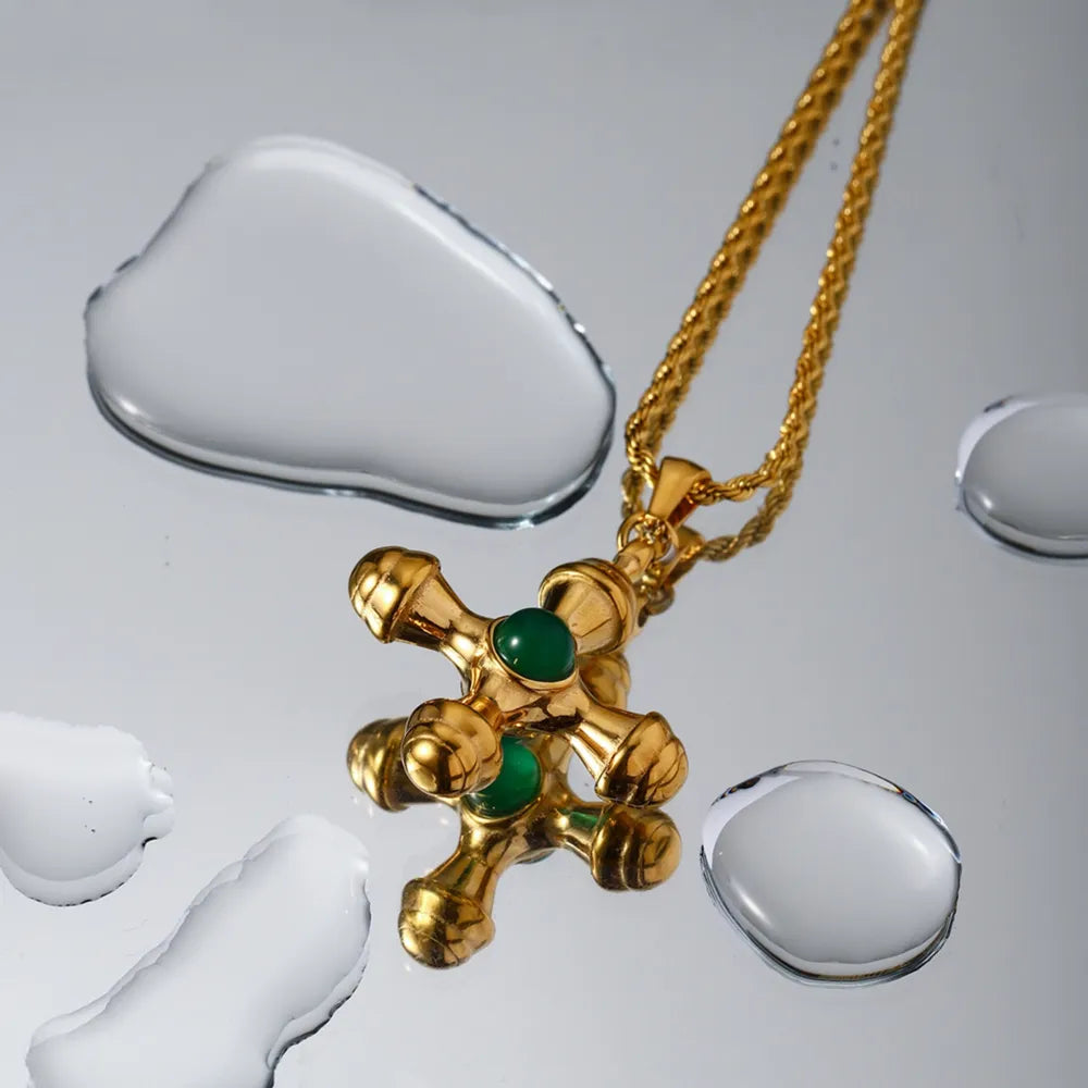 Gold Byzantine cross pendant necklace with green gemstones on a rope chain.