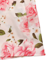 Romantic floral halter midi dress with pink roses and green leaves on a light background.
