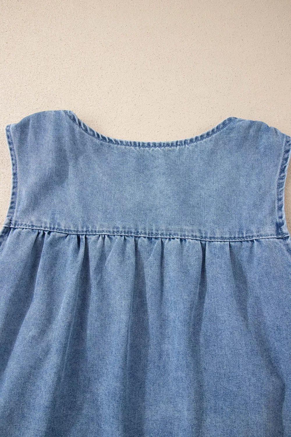 V-neck pleated denim sleeveless top with a relaxed fit.