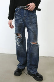 Dark wash denim jeans with distressed rips at the knees and a relaxed fit.
