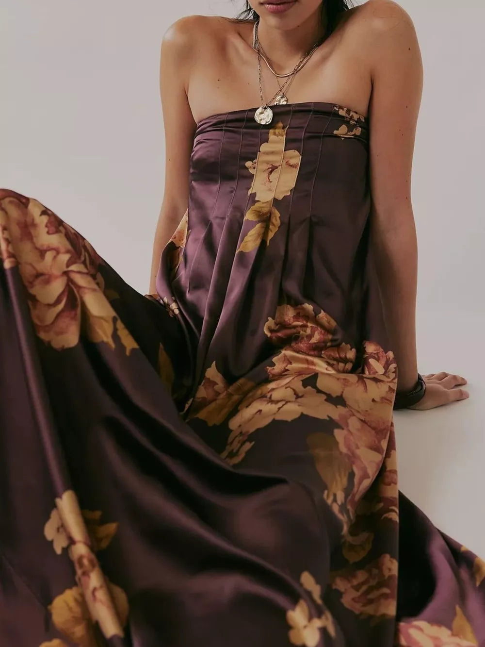 Strapless brown floral maxi dress with gathered bodice and flowing skirt.