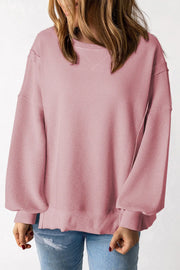 Dusty pink waffle knit pullover sweater with slit sleeves and crew neck.