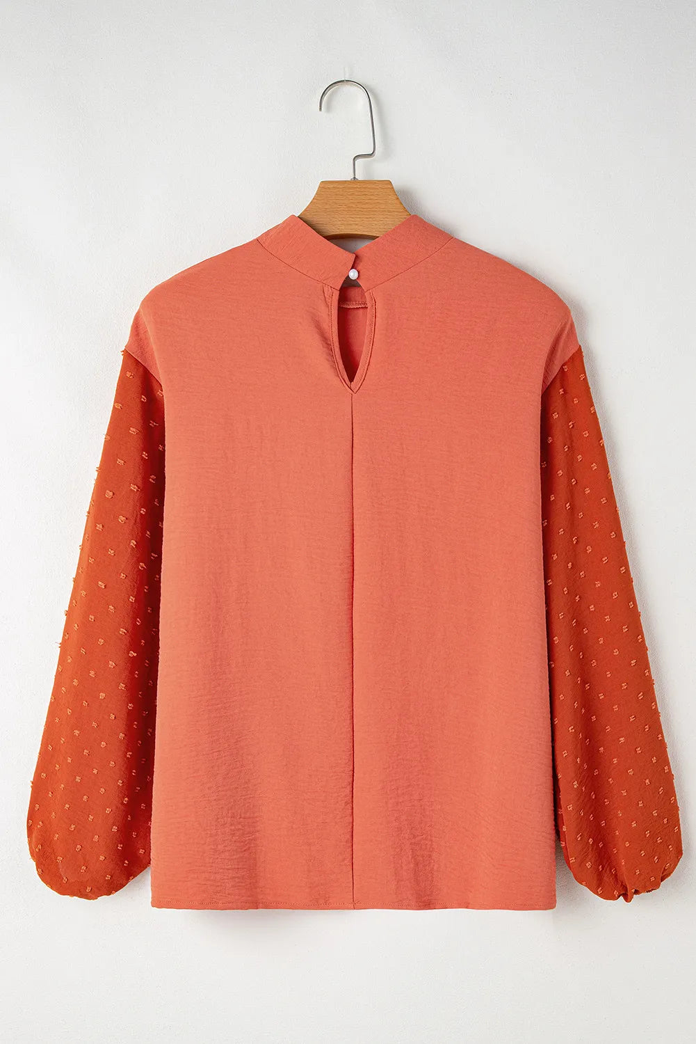 Orange blouson top with mock neck and Swiss dot sleeves