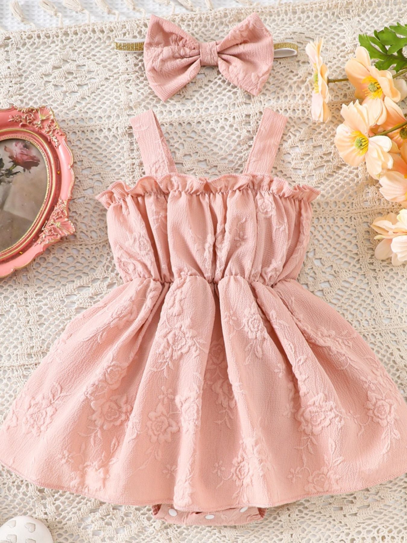 Pink floral embossed baby one-piece with ruffles and matching headband