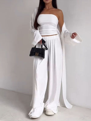 White three-piece outfit set with strapless top, wide leg pants, and open cardigan.