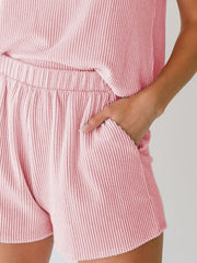 Chic sleeveless coord set in blush pink with ribbed texture and elastic waist shorts.