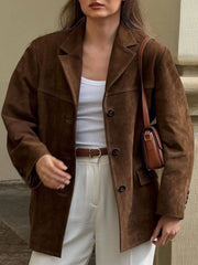 Brown suede blazer with structured shoulders and button closure, styled with a white tank and cream pants.