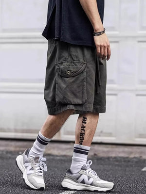 Army green cargo shorts with drawstring and button flap pocket detail.