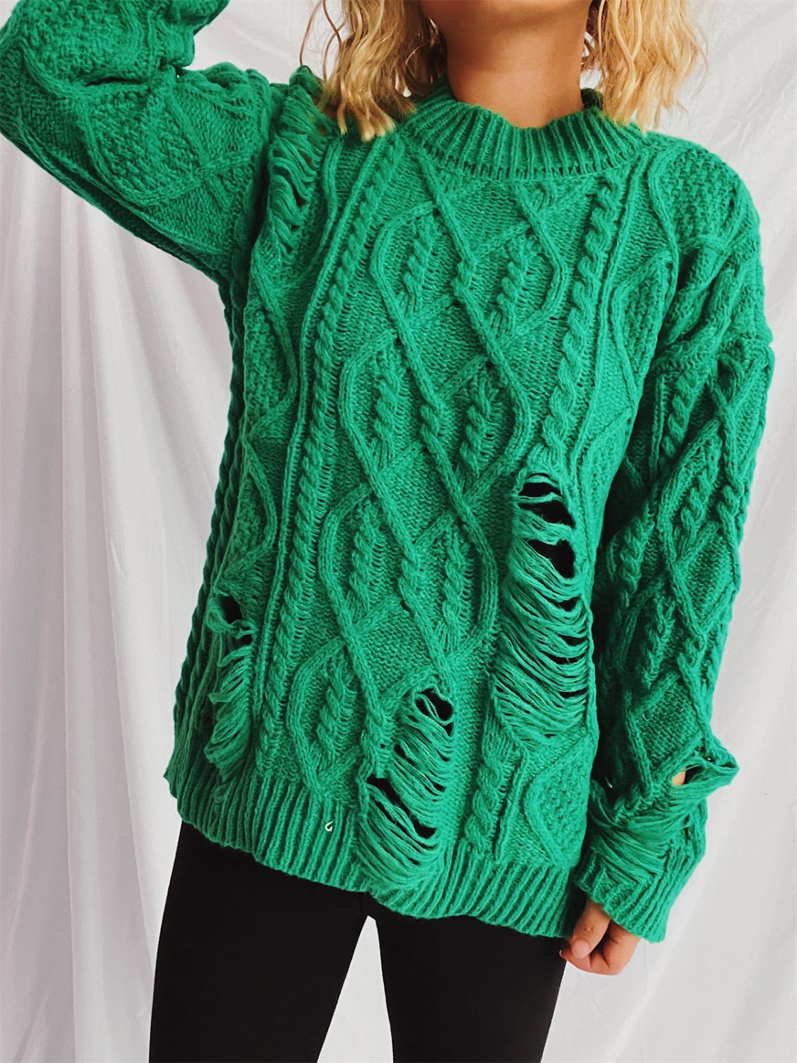 Green distressed cable knit sweater with ripped details and crew neck.