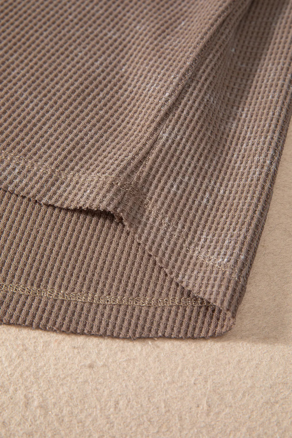 Luxe Notch Sleeve Blouse in taupe waffle knit fabric, showing hem detail