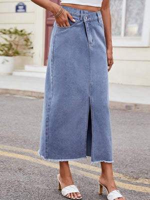 Light wash denim midi skirt with asymmetric front slit and frayed hem.