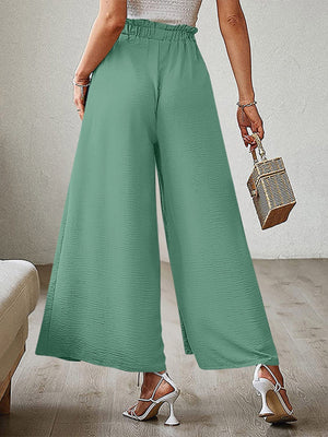 Matcha green paperbag waist palazzo pants with side slits and textured fabric.