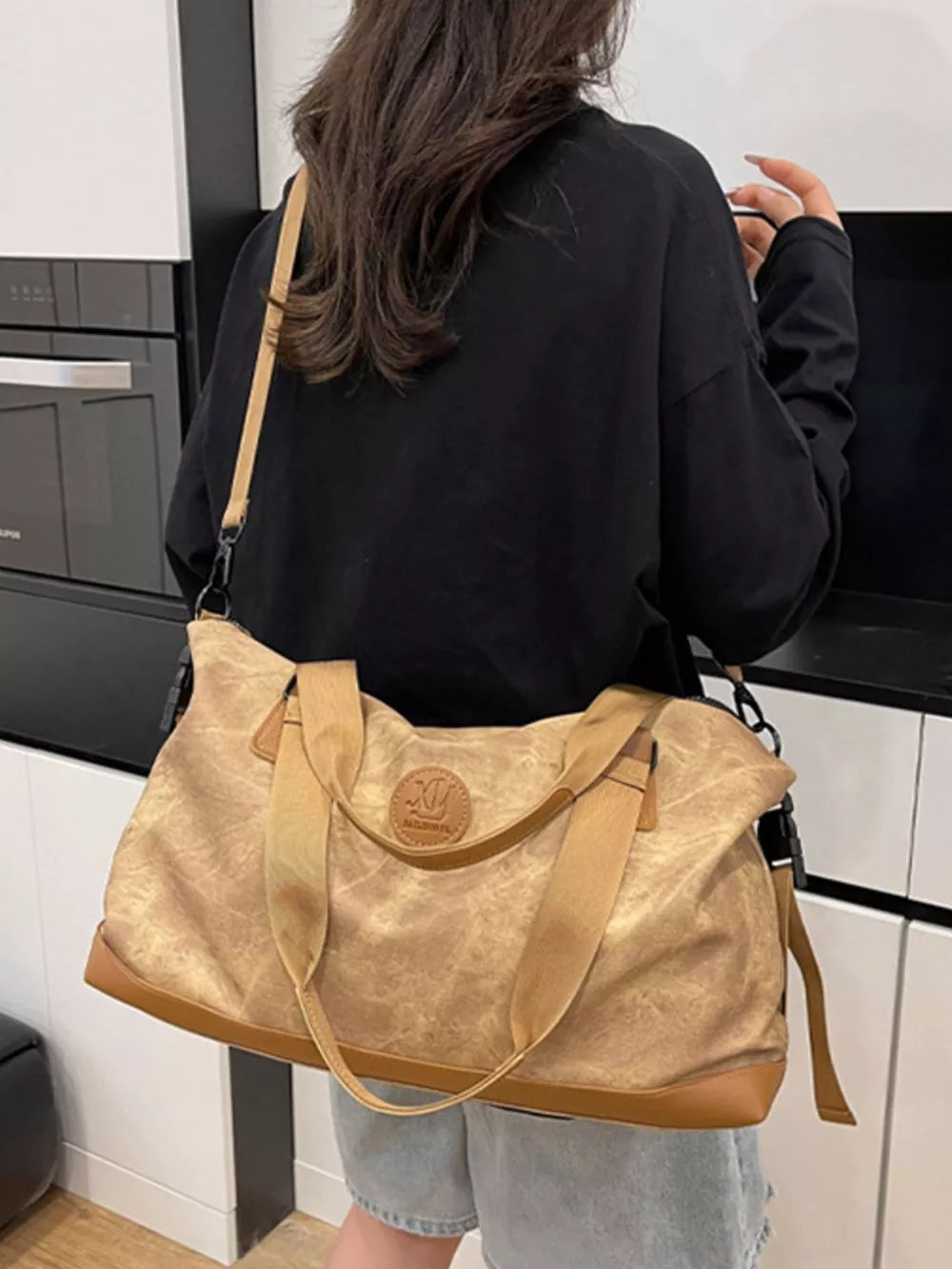 Brown Oxford cloth duffel bag with leather trim and detachable strap.