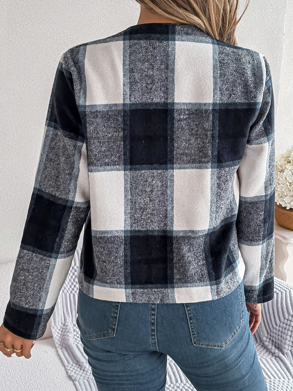 Collarless plaid cropped jacket in dark blue and white, with long sleeves.