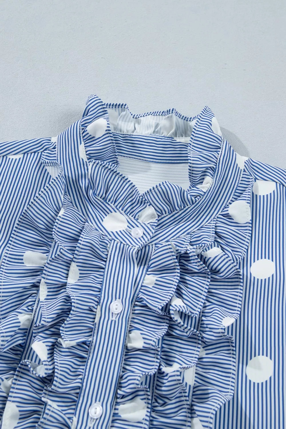 Blue and white striped button-down shirt with polka dots and ruffles.