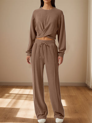 Brown knit loungewear set with a cross-front cropped top and wide-leg pants.
