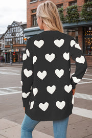 Black acrylic knit cardigan with white heart appliqué pattern.