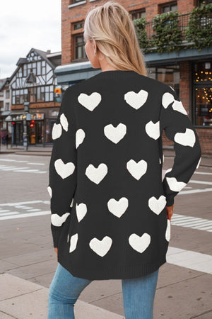 Black acrylic knit cardigan with white heart appliqué pattern.