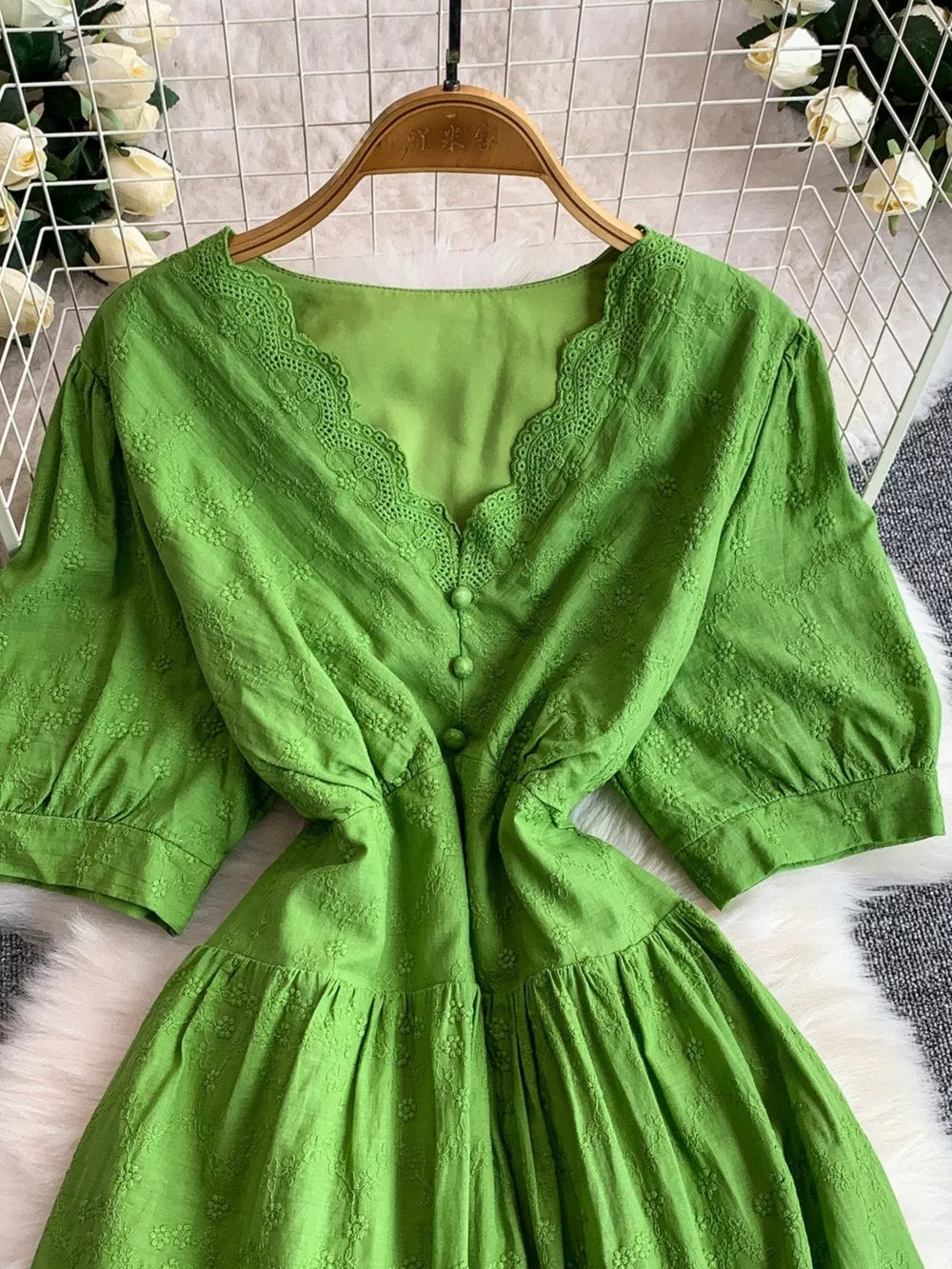 Green lace-embellished A-line midi dress with V-neck and button front.