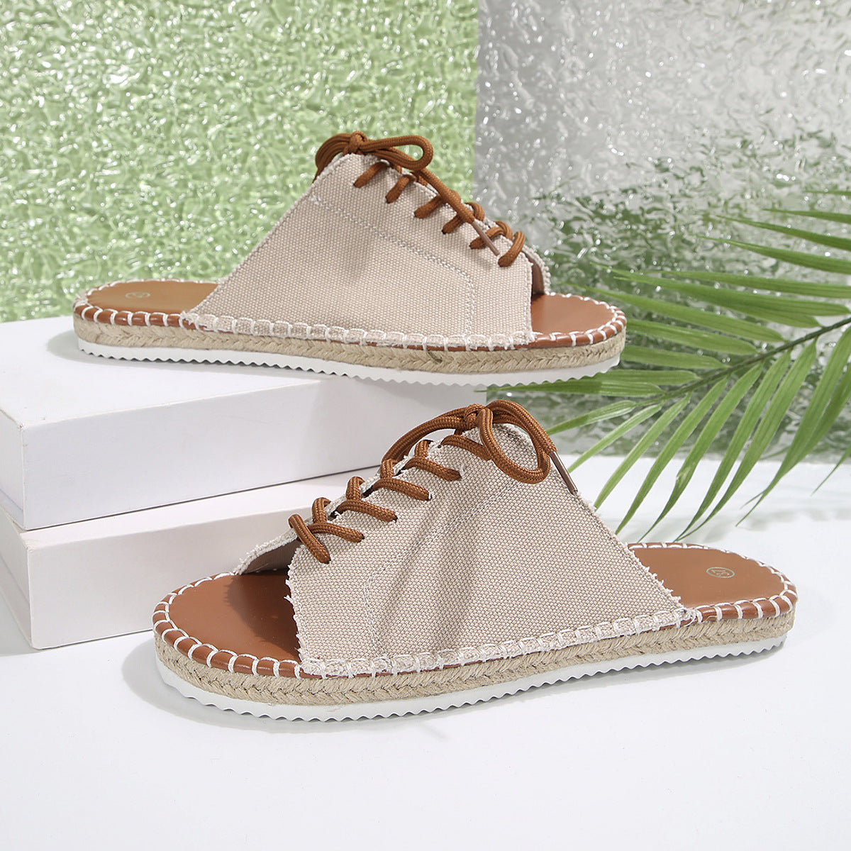 Luxe lace-up open-toe flats in off-white canvas with brown laces and espadrille trim.