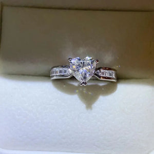 Silver ring with a heart-cut moissanite and baguette accents