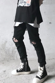 Black skinny fit denim jeans with distressed knees and ankle zippers.