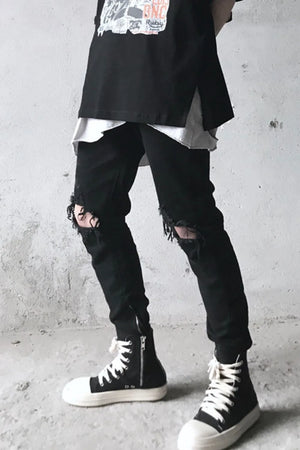 Black skinny fit denim jeans with distressed knees and ankle zippers.