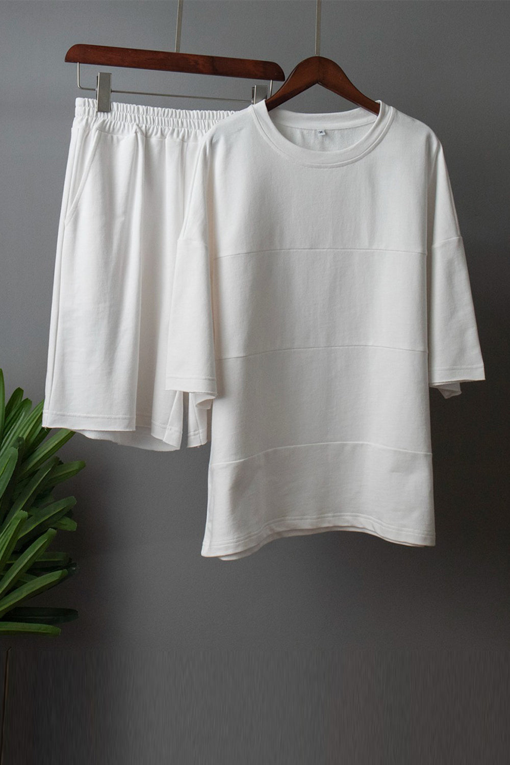 White relaxed fit sweatshirt with seam details and matching elastic waist shorts.