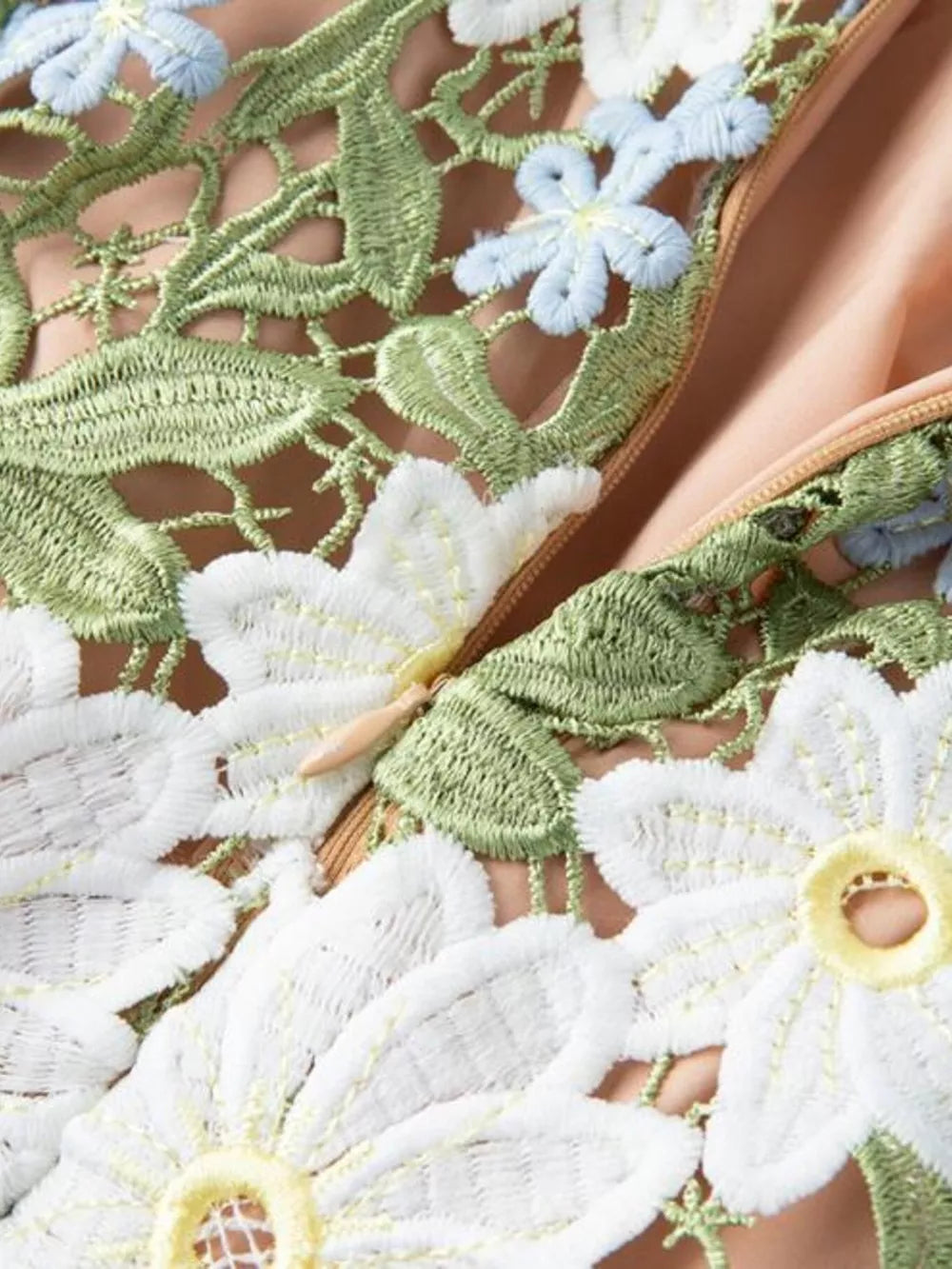 Embroidered floral maxi dress with appliqué detail and green leaves.