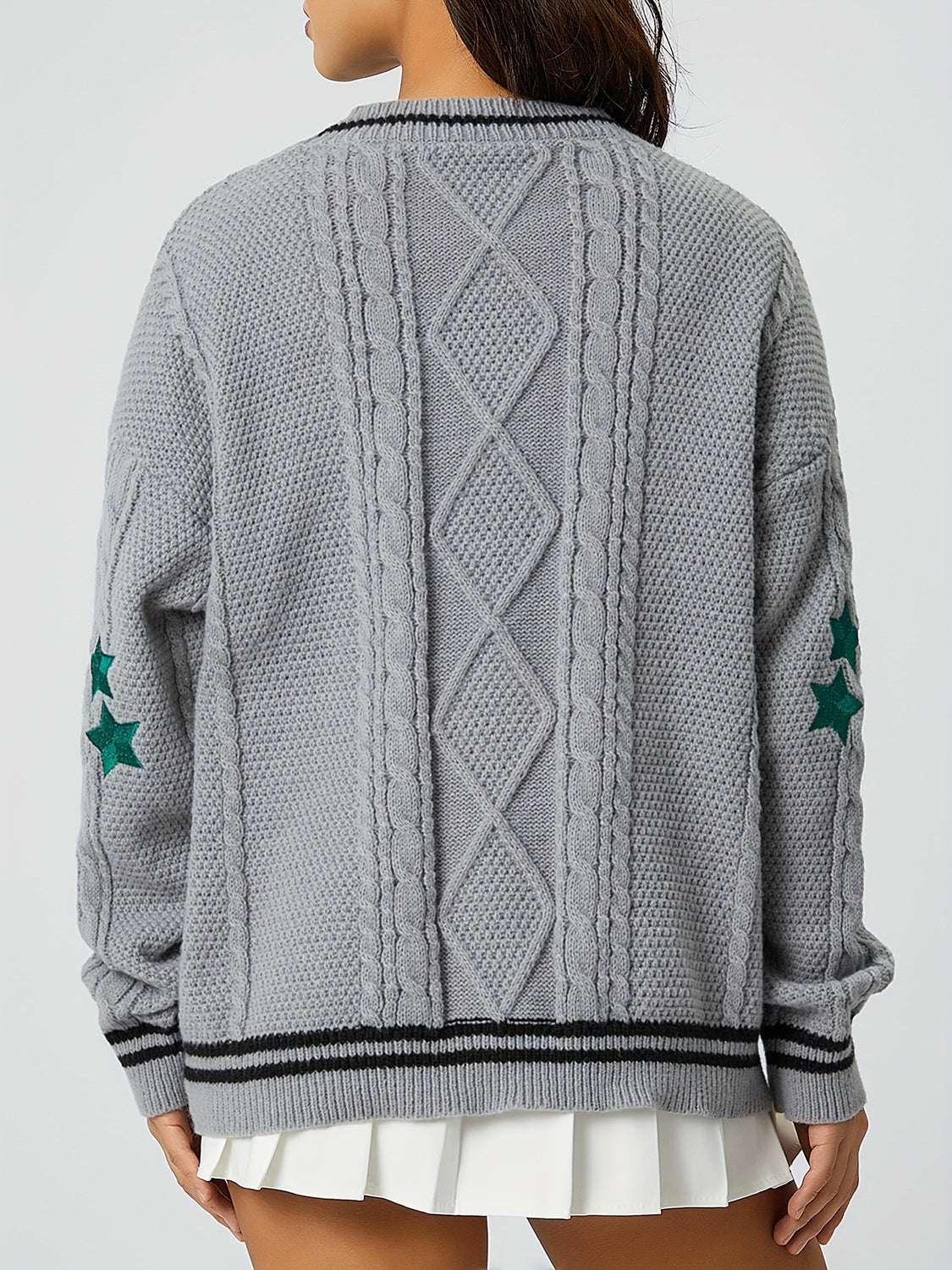 Gray cable knit cardigan with diamond pattern, stars on sleeve, and striped trim.