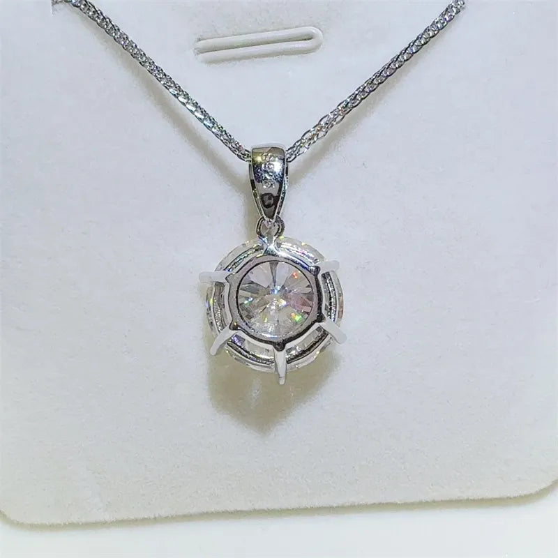 Silver moissanite solitaire pendant with a round-cut stone and prong setting.