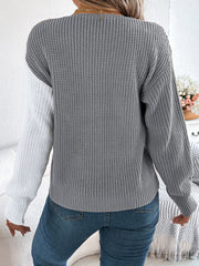 Asymmetrical colorblock knit sweater in gray and white with button detail.