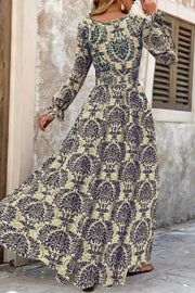 Maxi dress with bishop sleeves, cinched waist, and damask print in navy and sage.