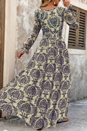 Maxi dress with bishop sleeves, cinched waist, and damask print in navy and sage.
