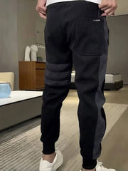 Men's dark gray slim-fit sweatpants with colorblock detail and drawstring.