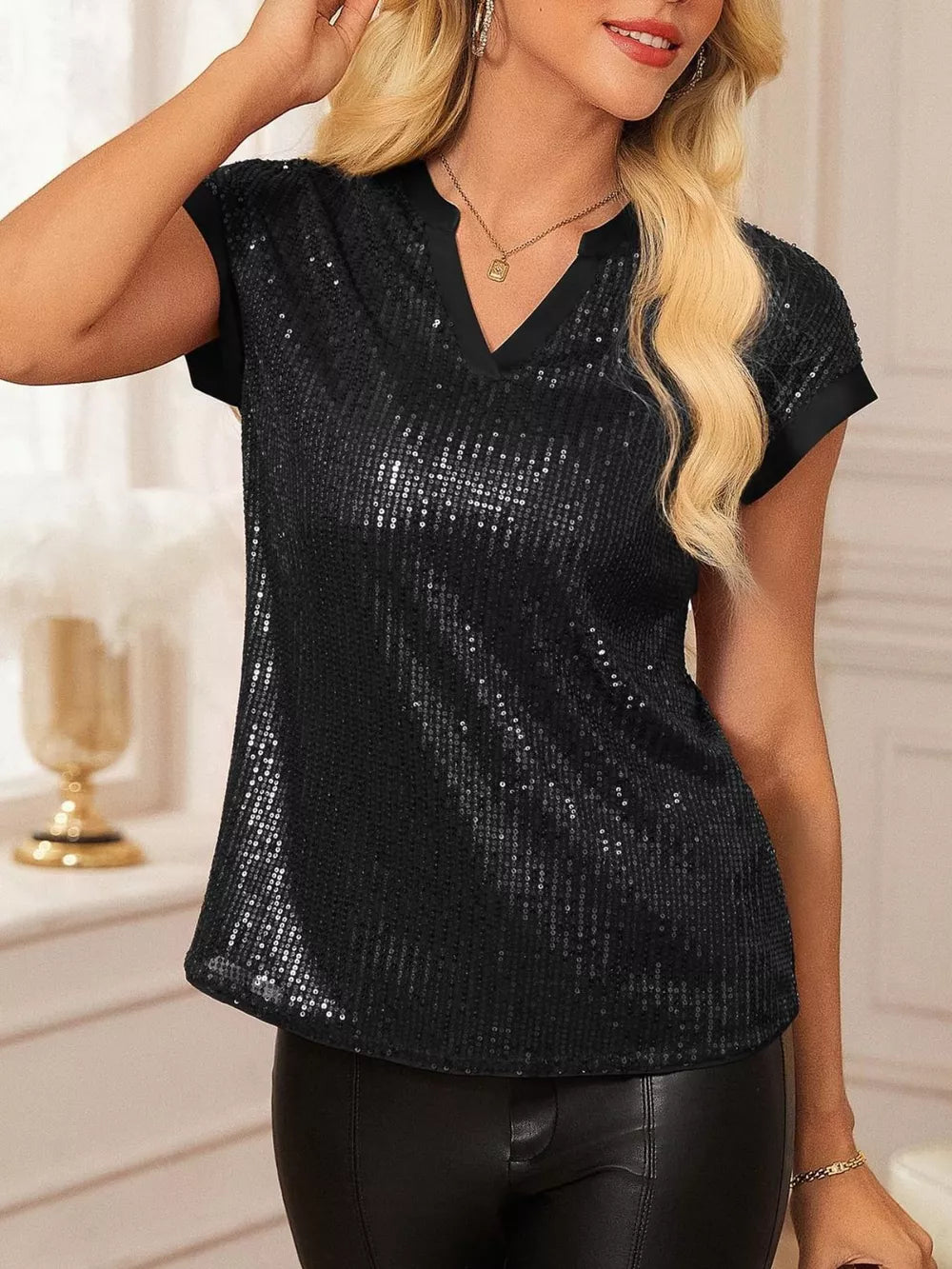 Black sequin cap sleeve blouse with V-neck and contrast trim.