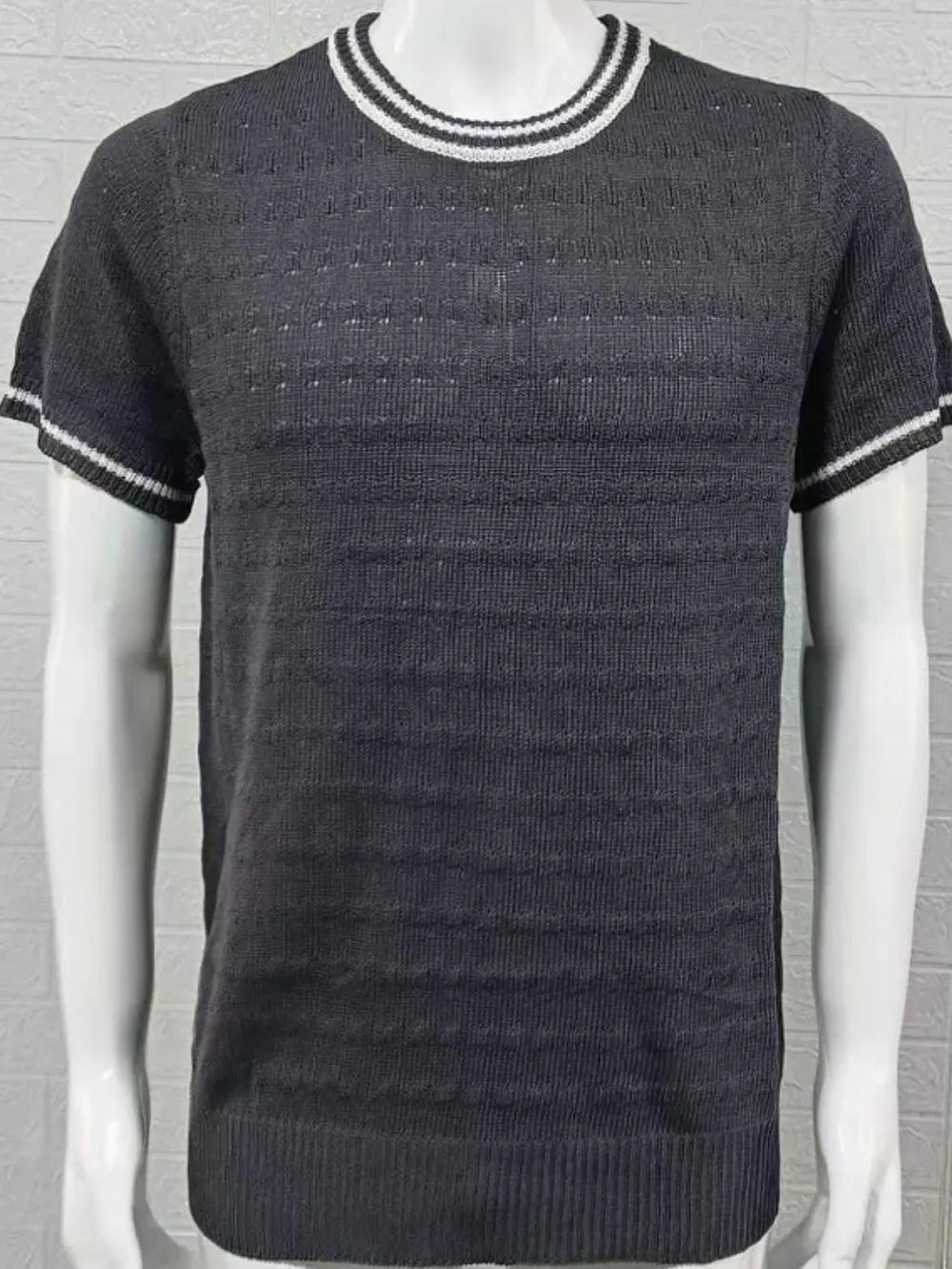 Textured knit t-shirt in black with white striped neckline and cuffs.