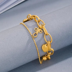 Gold charm bracelet with cross and heart charms
