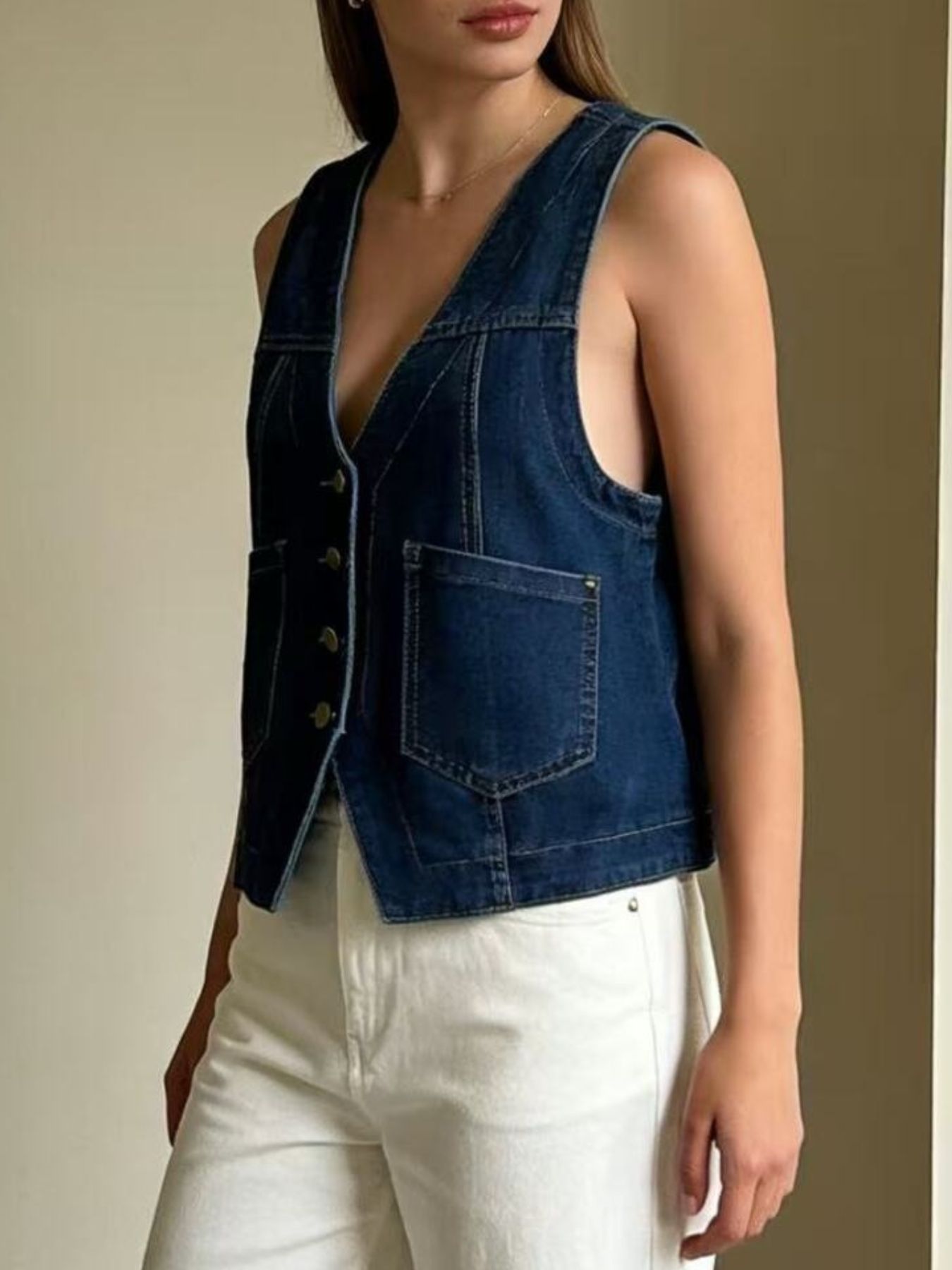 Dark blue denim button-down vest with brass buttons and chest pockets