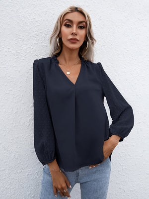 Dark blue Swiss dot sleeve gathered blouse with V-neck and cinched cuffs.