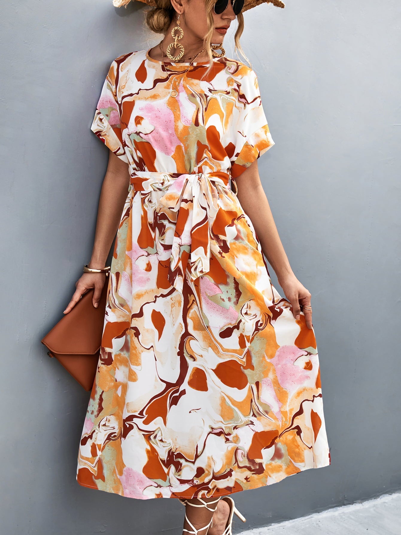 Midi dress with abstract print, tie waist, and short sleeves in orange-red and blue tones.