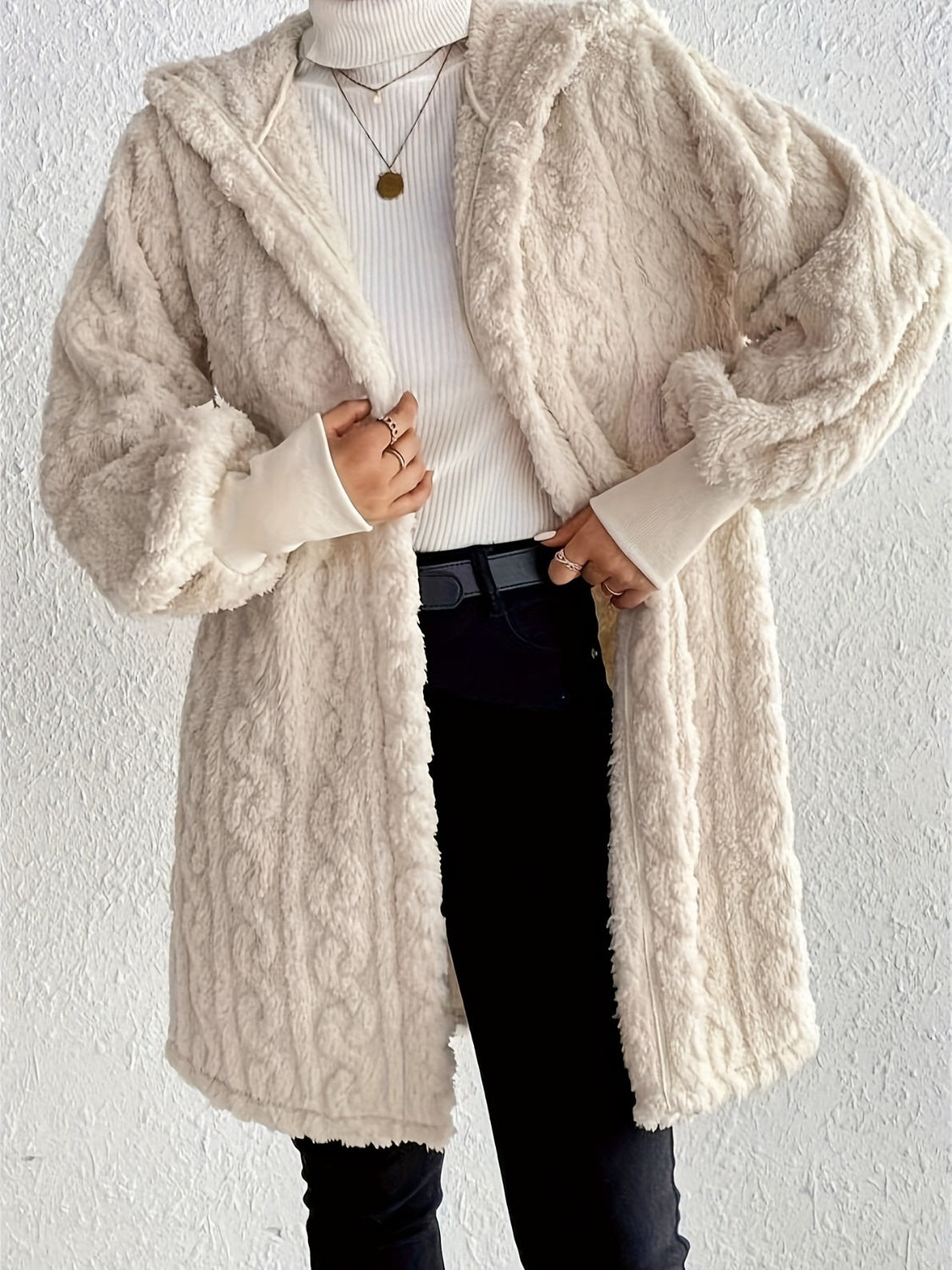 Beige hooded cocoon coat with textured cable knit, 100% polyester, open front.
