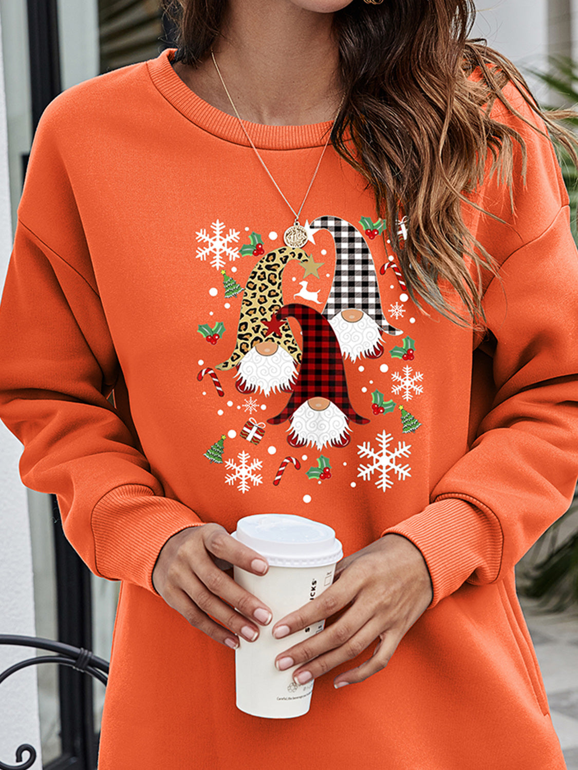 Orange crewneck sweatshirt tunic with festive gnome graphic, snowflakes, and holiday accents.