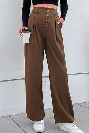 Brown high-waisted tailored wide-leg trousers with button front and pleats.