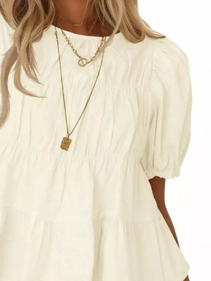 Cream white maternity blouse with puff sleeves, ruffled tiers, and smocked bodice detail.