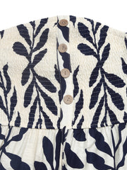 Chic smocked tube romper in ivory with navy leaf print and wooden button detail.