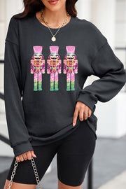Black ribbed sweatshirt with three sequined nutcracker embellishments, crew neck, long sleeves.