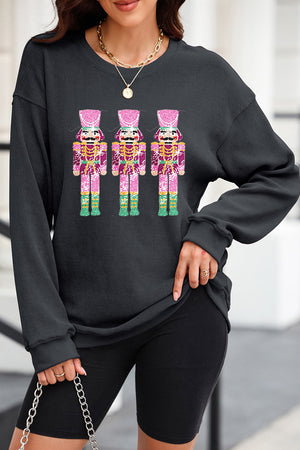Black ribbed sweatshirt with three sequined nutcracker embellishments, crew neck, long sleeves.