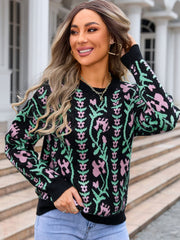 Black crewneck sweater with floral tapestry pattern in pink and green acrylic knit
