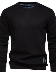 Black crewneck sweatshirt with subtle patch detail on hem